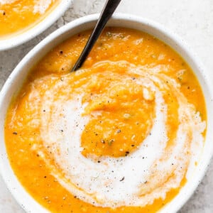 Acorn squash soup topped with a swirl of cream.