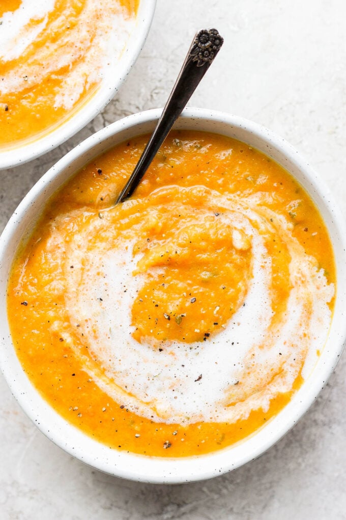 Acorn squash soup topped with a swirl of cream.