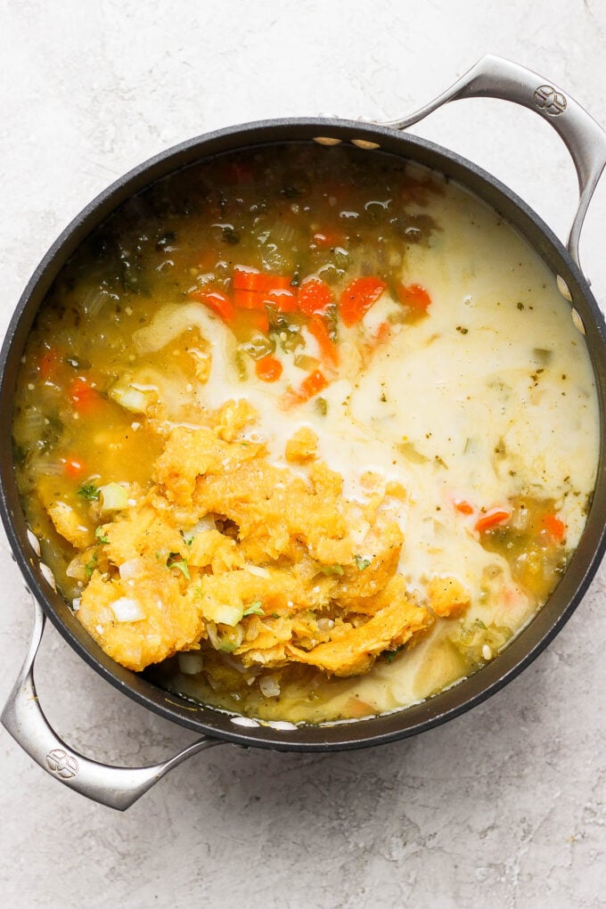 Adding squash and milk to a soup pot.