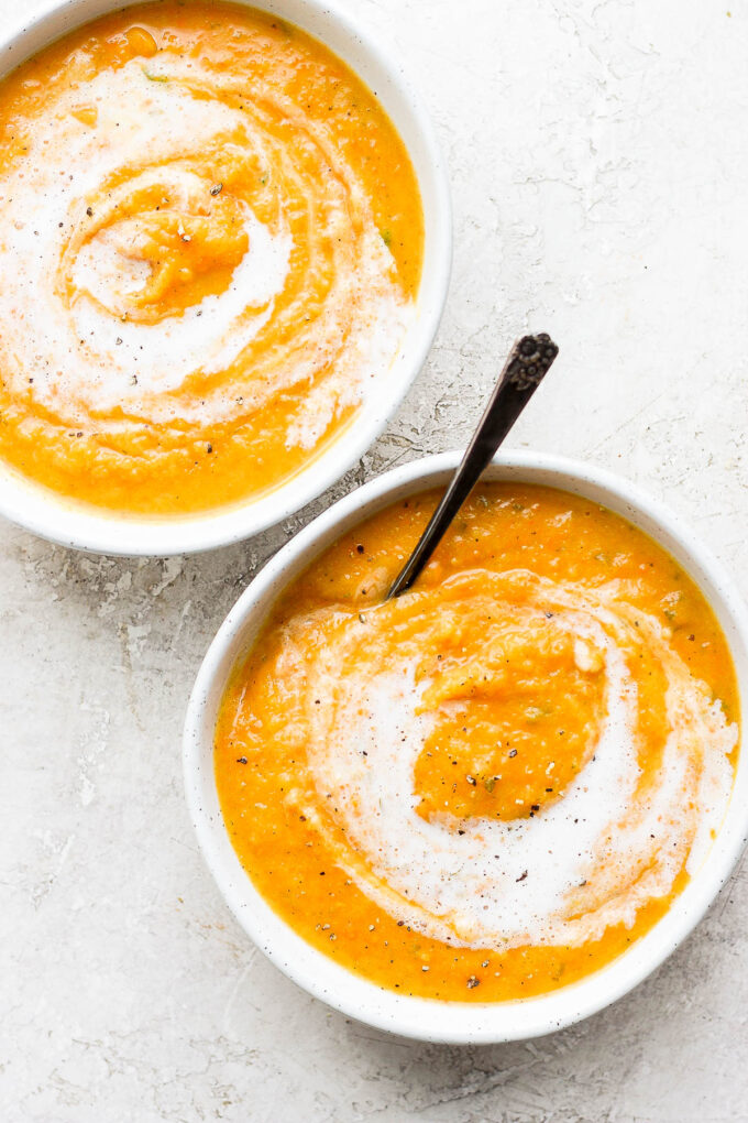 Two servings of creamy soup in white bowls.