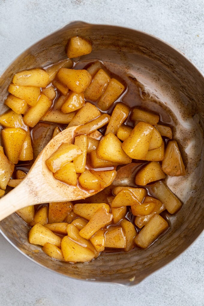 Sautéing cinnamon apples in a pot.