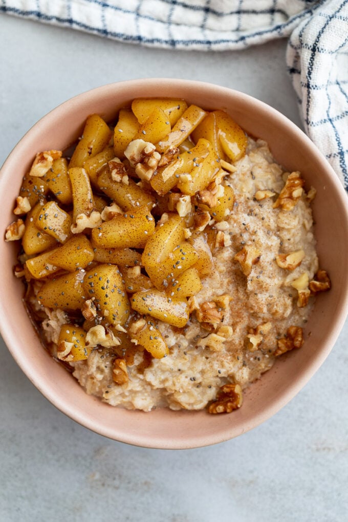 Apple cinnamon oatmeal in a bowl topped with caramelized apple.