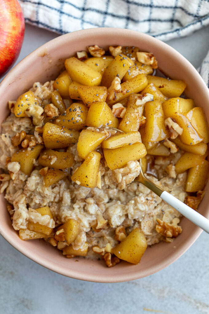 Spoon stirring apple pie oatmeal.