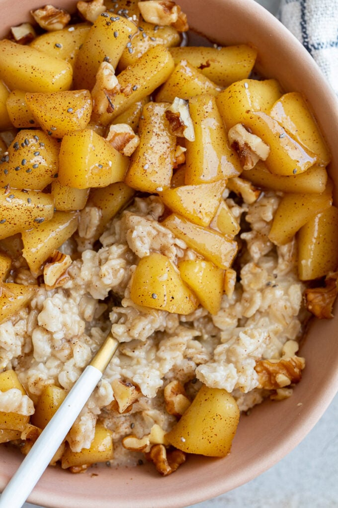 Bowl of oatmeal topped with cinnamon apples.