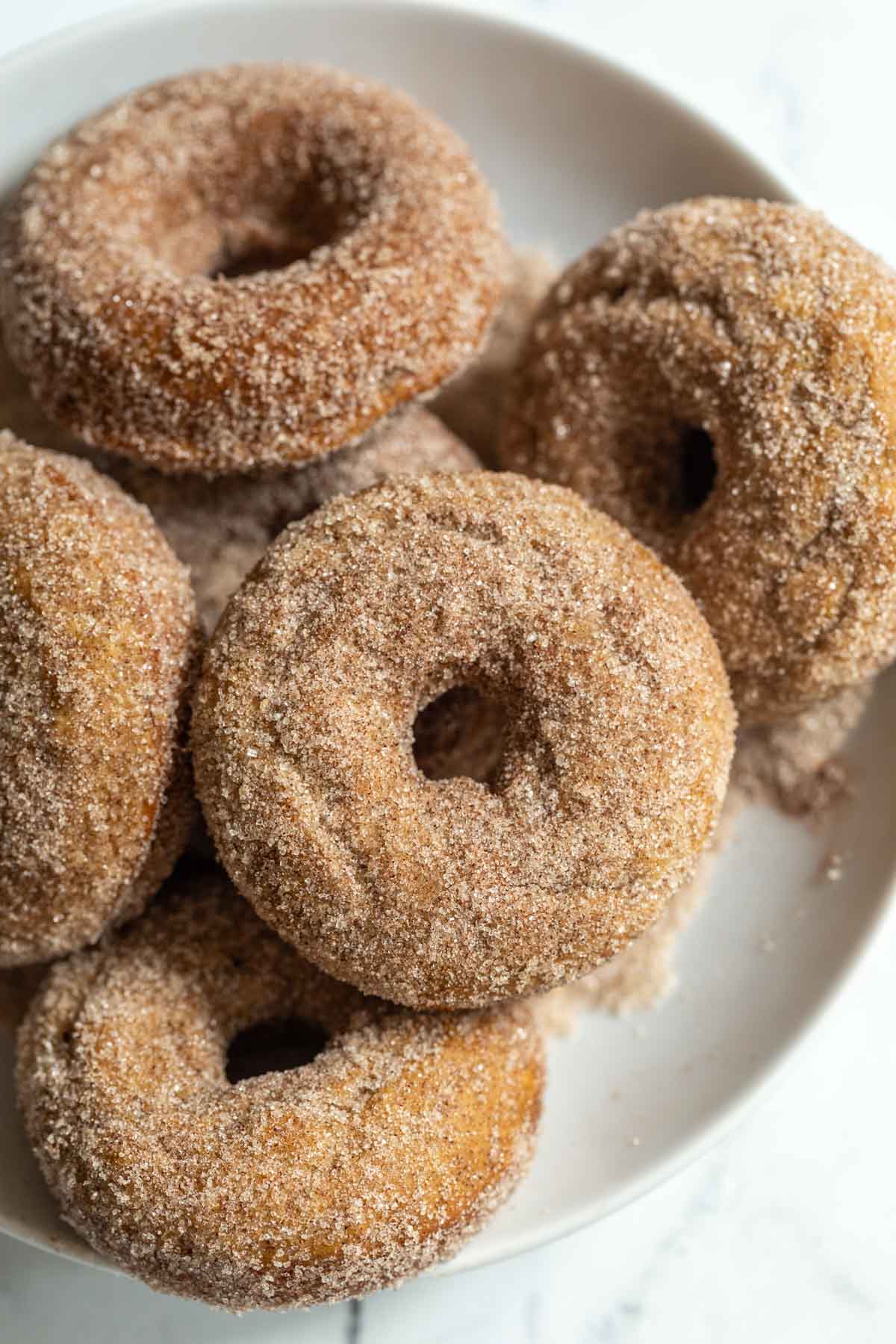 cinnamon sugar donuts stacked up in a bowl