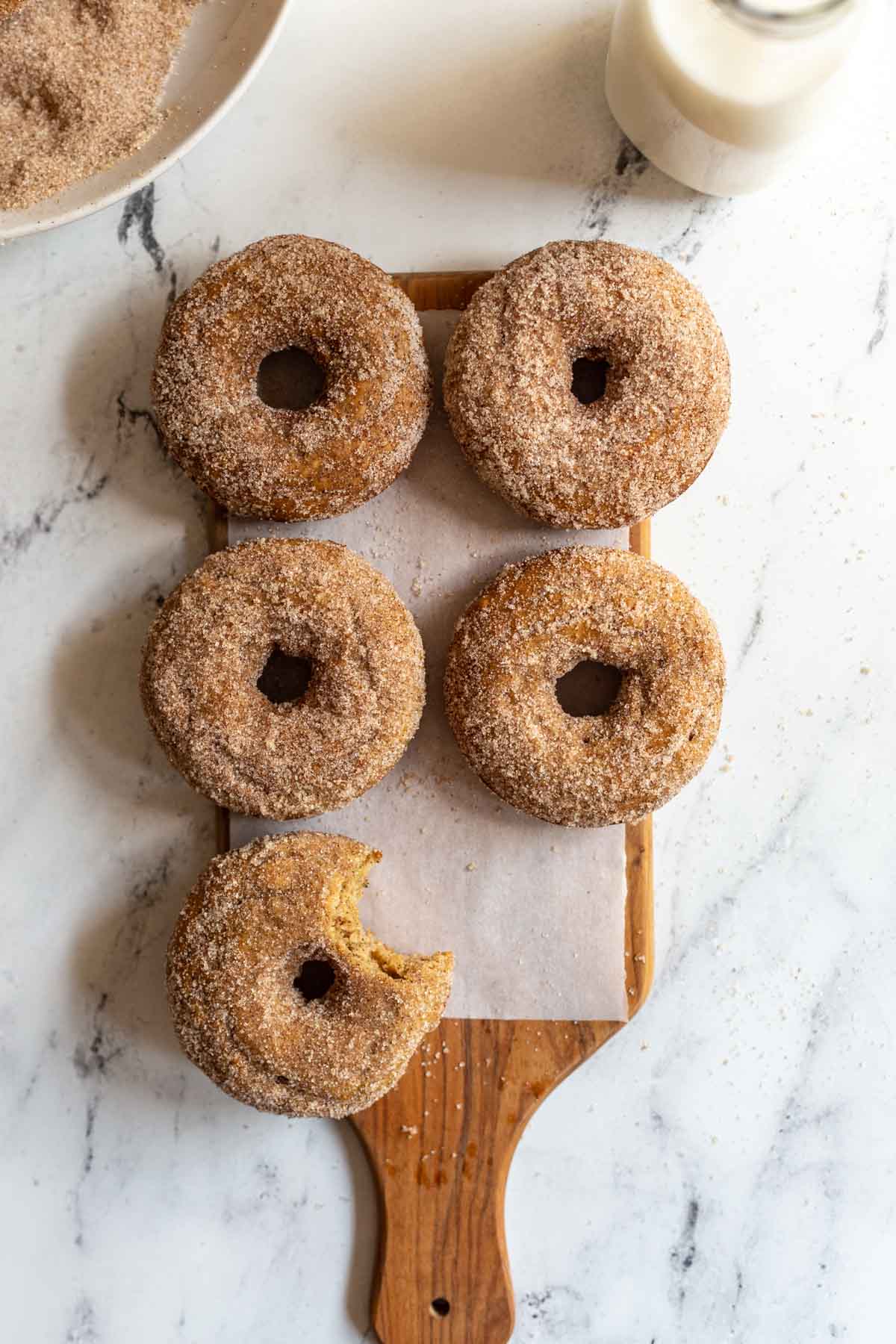 cinnamon sugar donuts on a wood board and marble slab