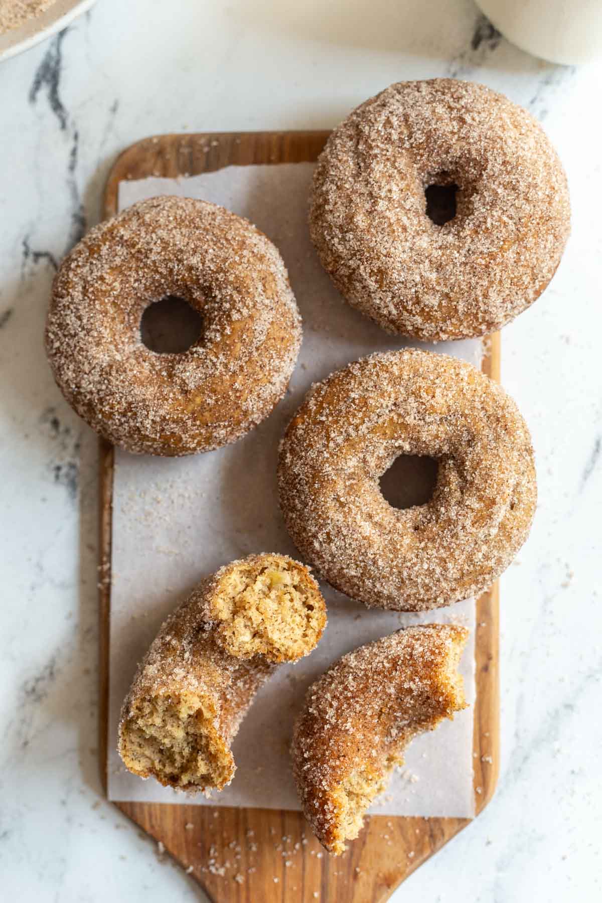 cinnamon sugar donuts on a wood board and marble slab