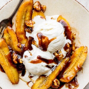 bananas foster served in a white bowl with ice cream