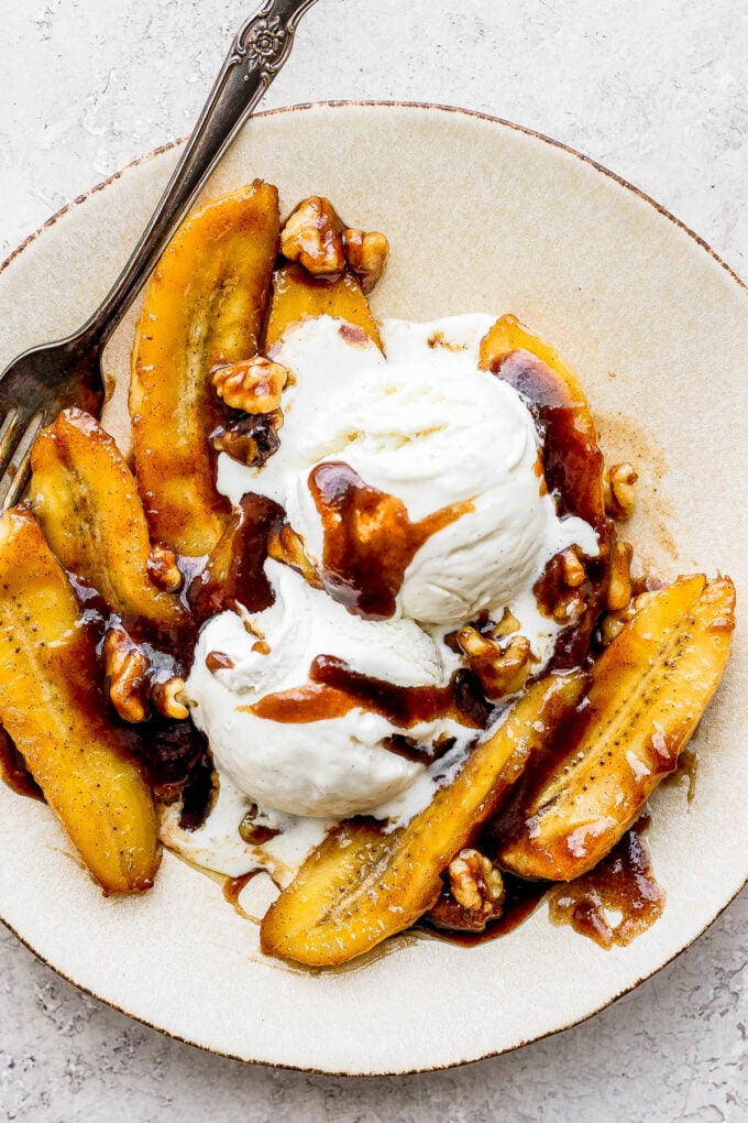 bananas foster served in a white bowl with ice cream