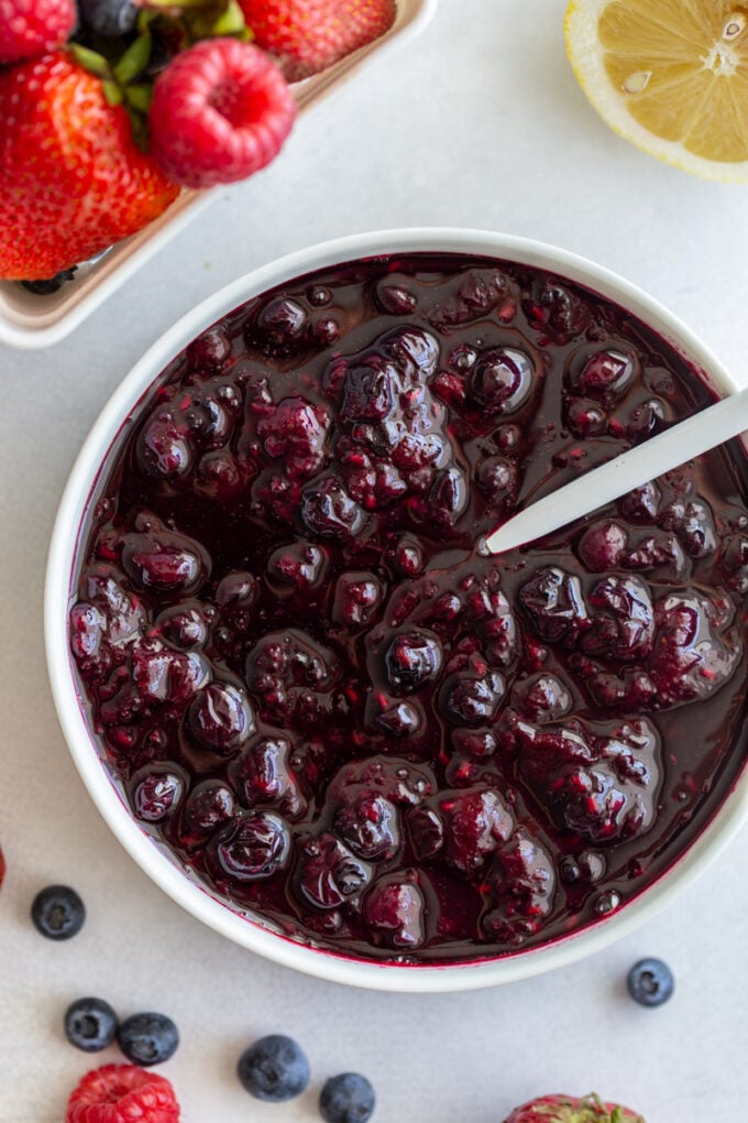 mixed berry compote in a large bowl with a spoon