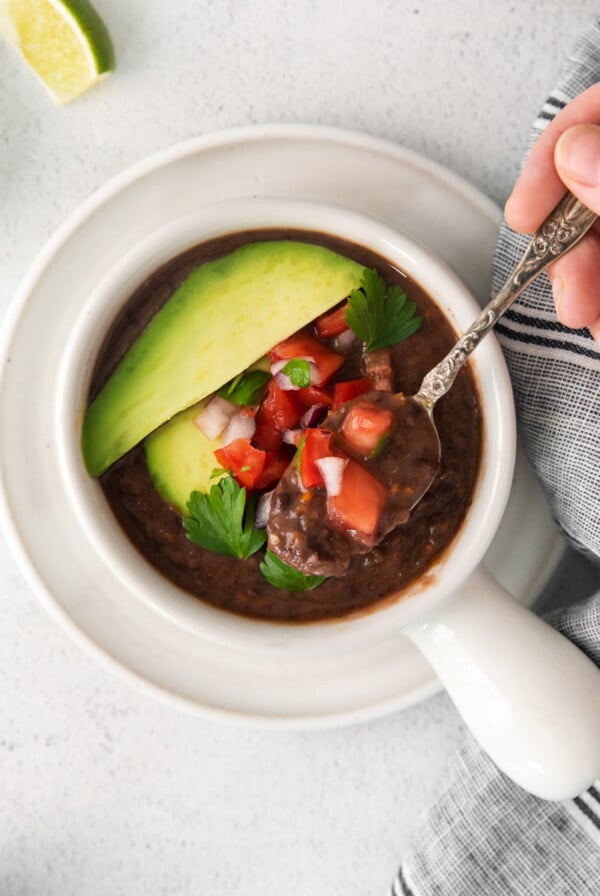 black bean soup topped with avocado and diced to tomatoes