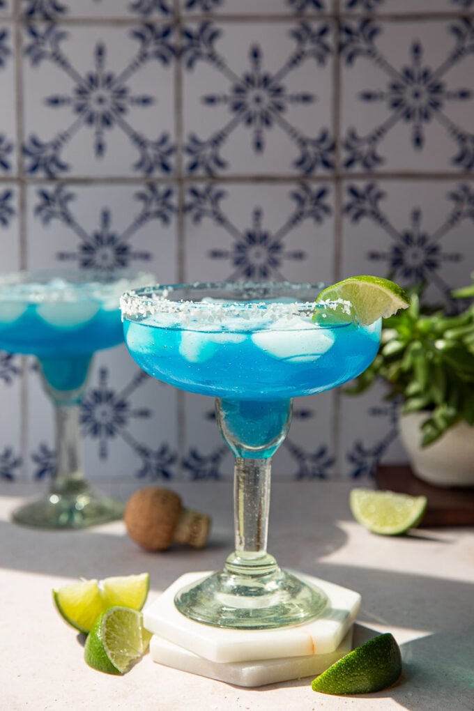 Blue margarita served in a salted margarita glass.