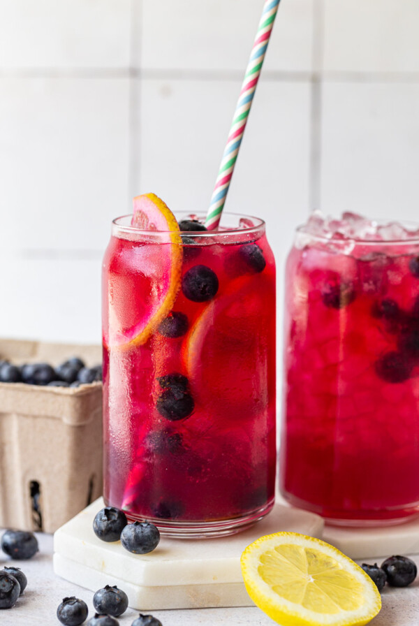 Blueberry lemonade served with a straw.