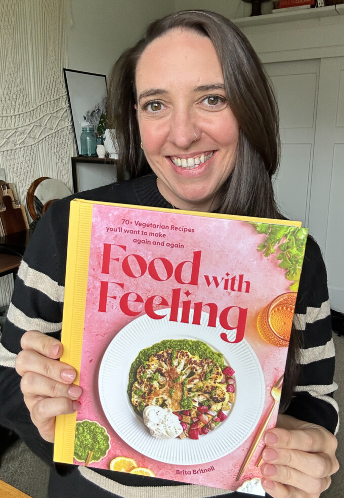 brita britnell holding the Food with Feeling Cookbook