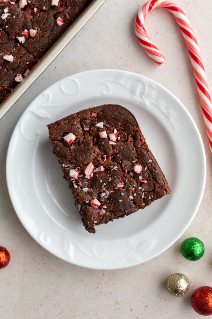 slice of chocolate peppermint baked oats topped with crushed peppermint on a white plate