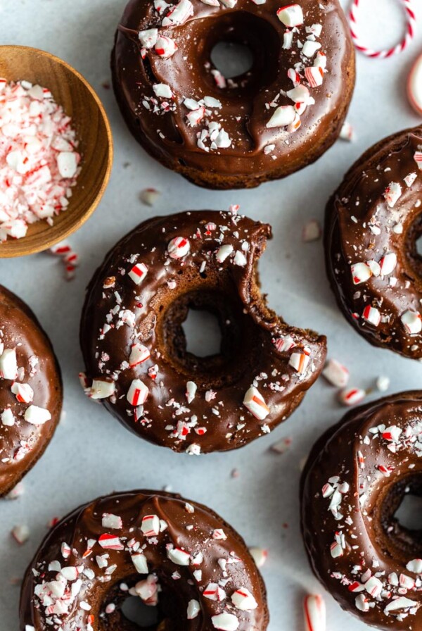 top down shot of chocolate donuts with a chocolate frosting and crushed peppermint on top