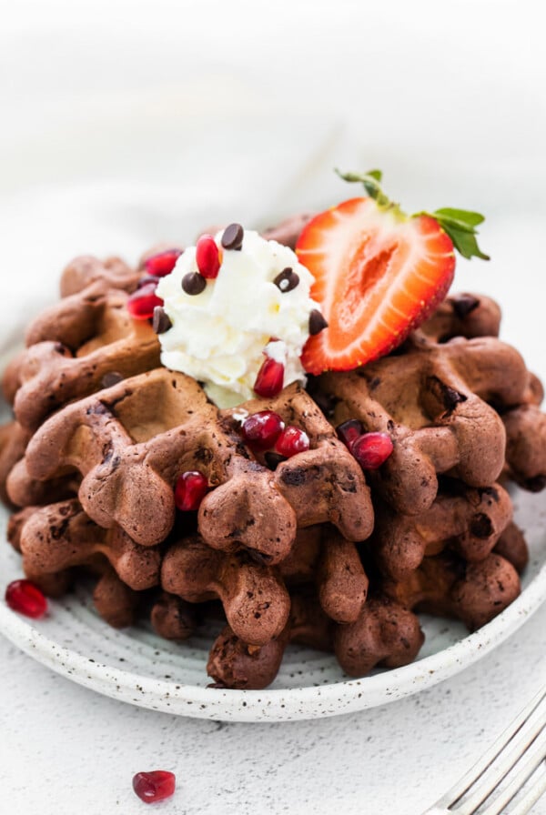 chocolate waffles topped with whipped cream and strawberries