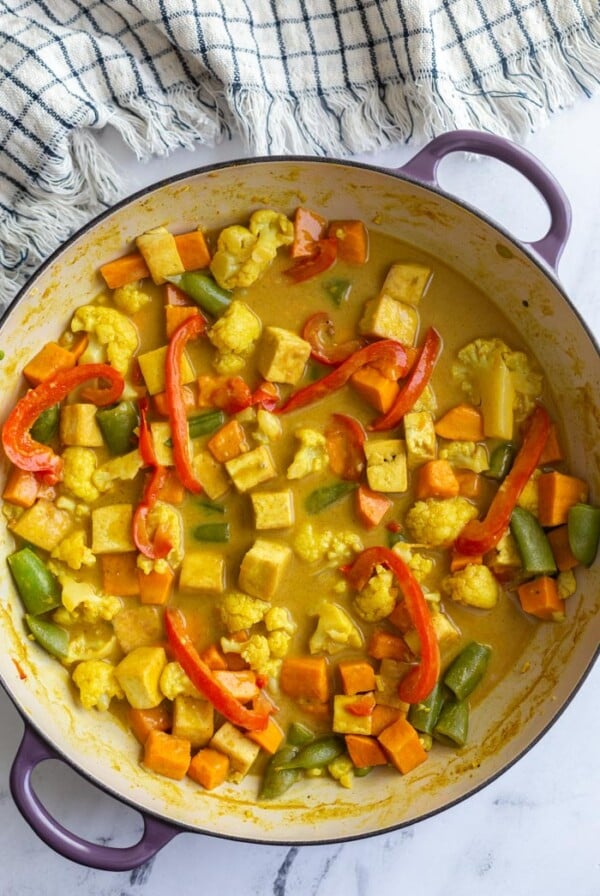 tofu coconut curry in a large skillet with a napkin in the corner