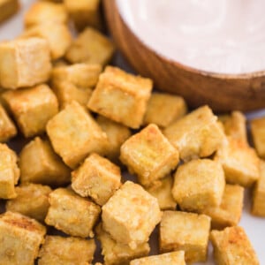 plate full of baked tofu with spicy mayo in the background