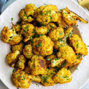 Curried cauliflower served in a white bowl.