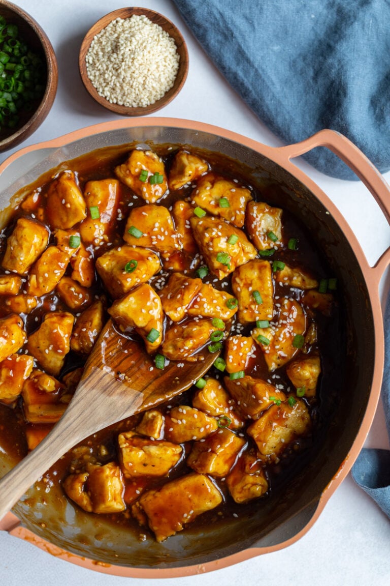 General Tso Tofu in a skillet with a wooden spoon