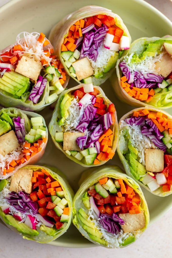 giant summer rolls stuffed with cabbage, radish, avocado, bell pepper, cucumber, tofu, and carrot. they're cut in half so you can see everything inside