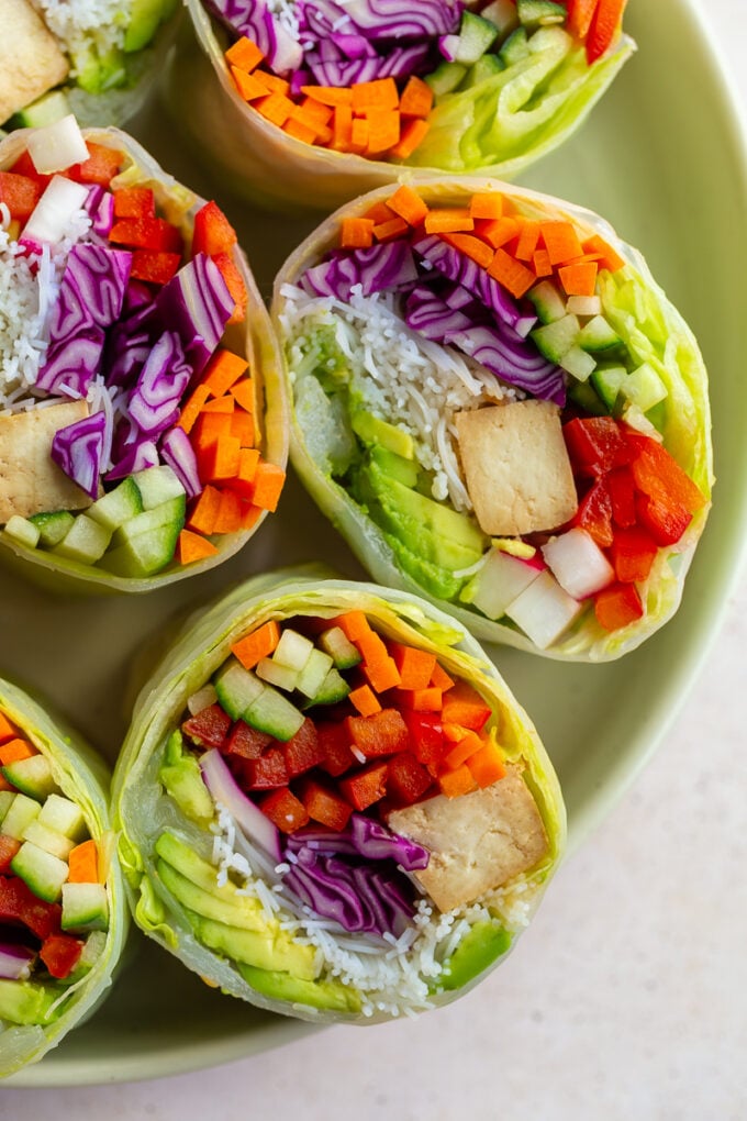 giant summer rolls stuffed with cabbage, radish, avocado, bell pepper, cucumber, tofu, and carrot. they're cut in half so you can see everything inside