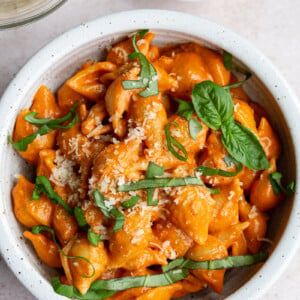 Pasta shells with sauce and topped with fresh basil.