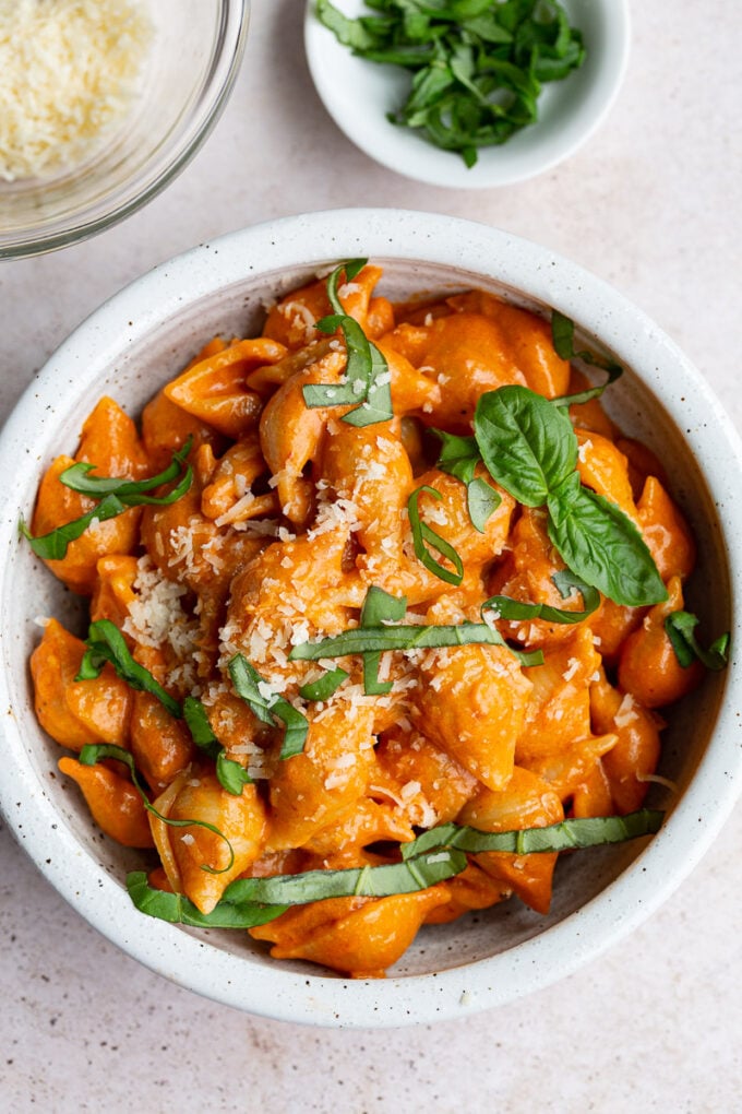 Pasta shells with sauce and topped with fresh basil.