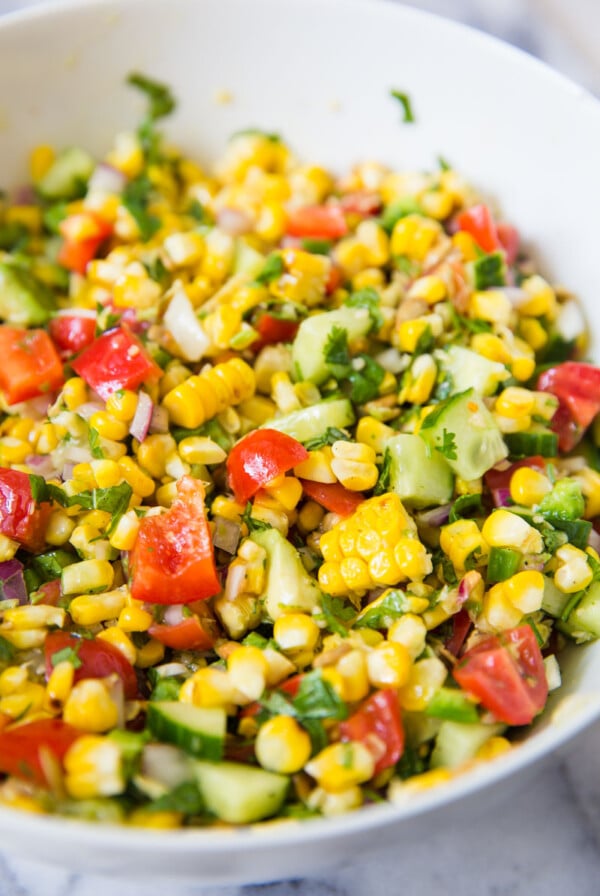 Grilled corn salad in a white serving bowl.