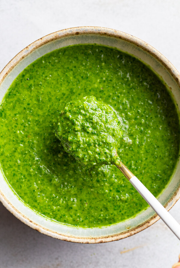 Using a spoon to serve Chimichurri sauce.