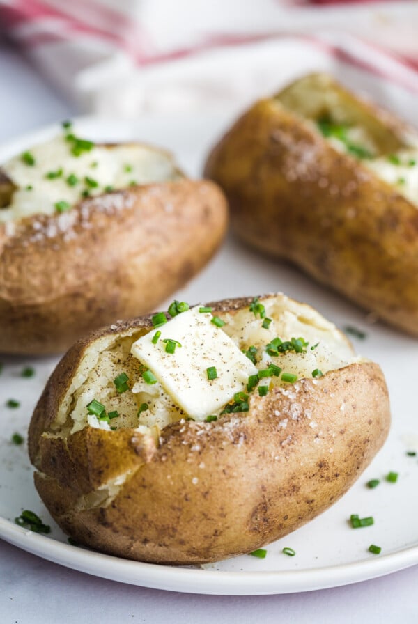 baked potato topped with pad of butter and chives