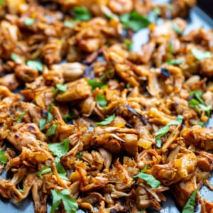 shredded jackfruit carnitas on a baking tray and topped with cilantro