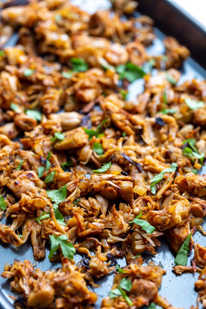 shredded jackfruit carnitas on a baking tray and topped with cilantro