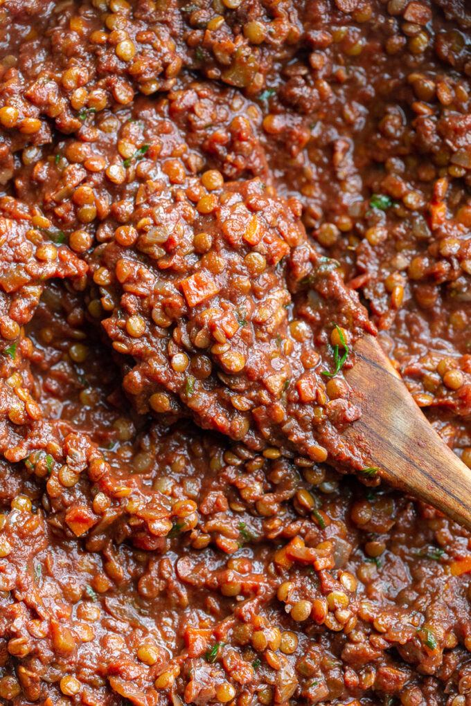 Lentil sauce on a wooden spoon.