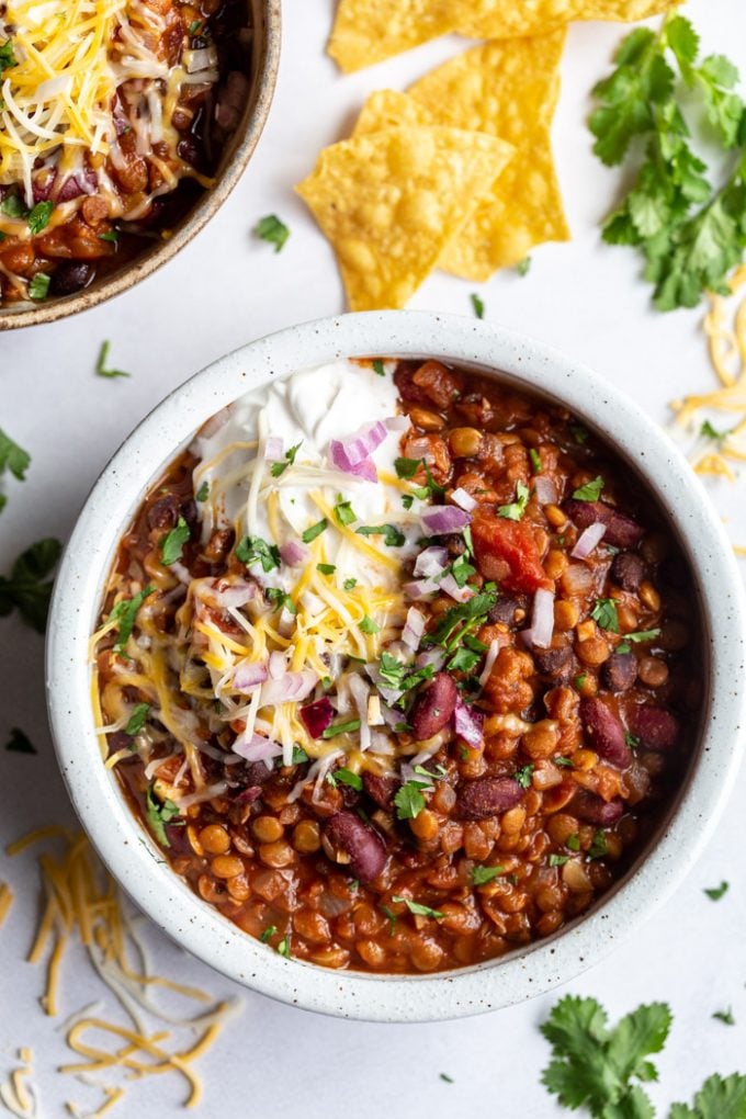 lentil and bean chili topped with cheese, cilantro and sour cream