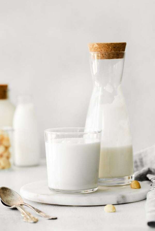 macadamia nut milk in a milk jug and small glass