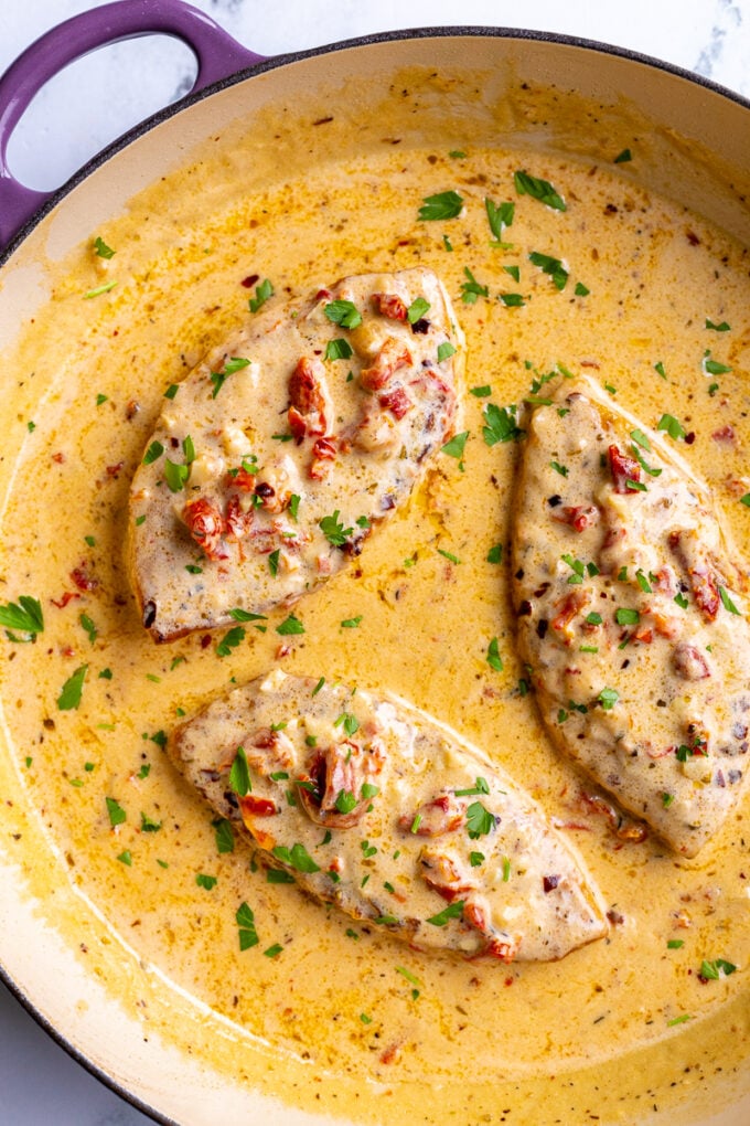 3 pieces of tuscan inspired marry me tofu in a large skillet with lots of creamy sauce in it.