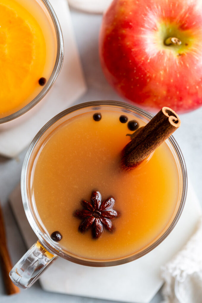 Mulled cider drink garnished with star anise and a cinnamon stick.