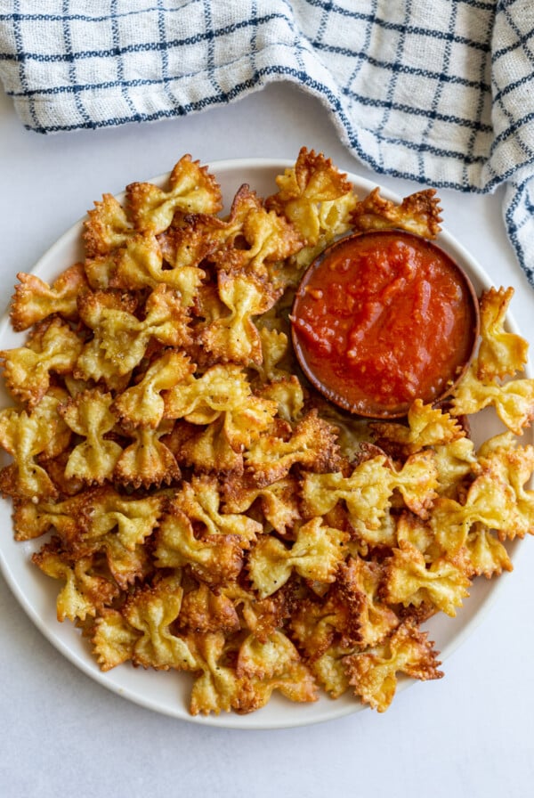 pasta chips on a plate with a bowl of marinara
