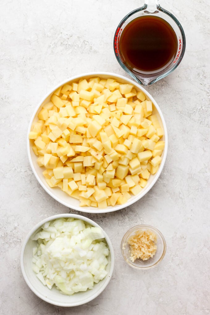 Ingredients for potato soup divided into small bowls.