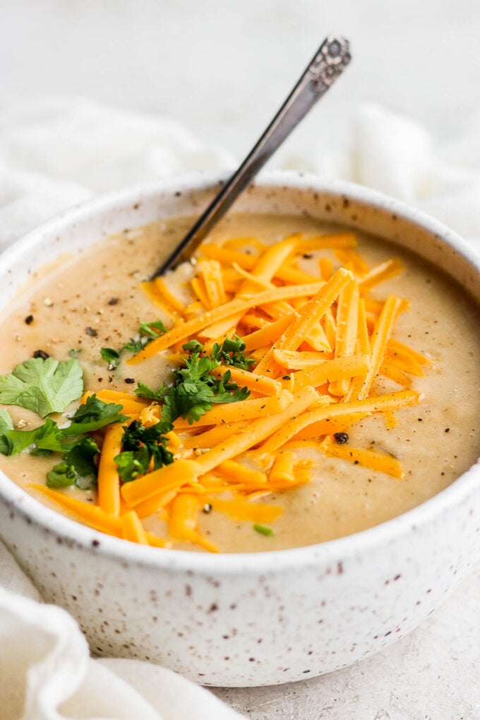 Potato soup topped with fresh parsley and cheddar cheese.