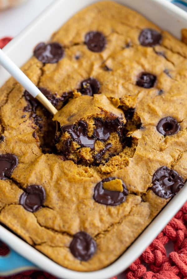 pumpkin baked oatmeal with chocolate chunks. A spoonful coming out of the middle of the dish