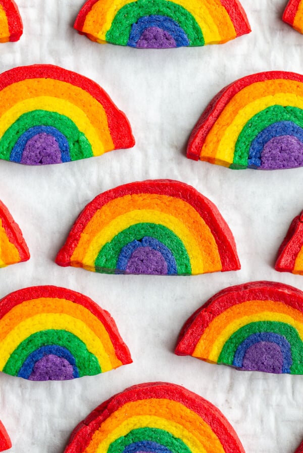 sugar cookies that look like rainbows all lined up on a baking sheet