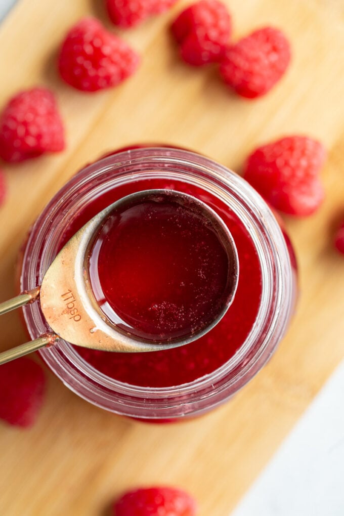 Serving raspberry juice from a small glass jar.