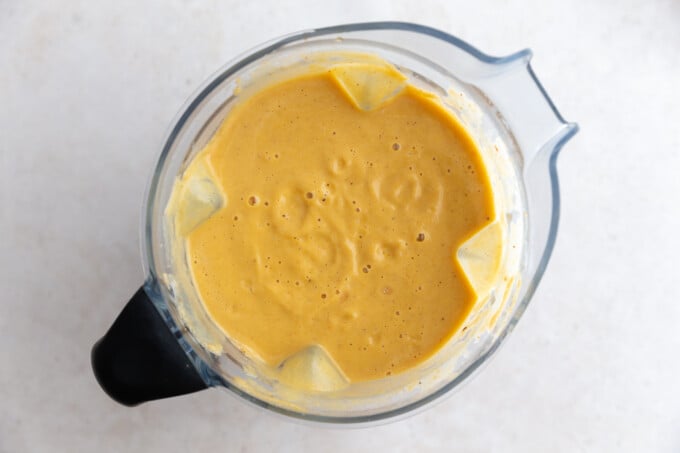 blender filled with orange cauliflower soup that was just blended up