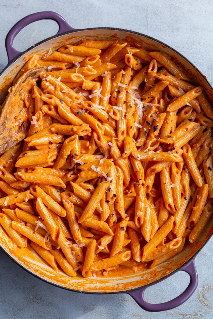 Penne pasta tossed in rose sauce in a large pot.