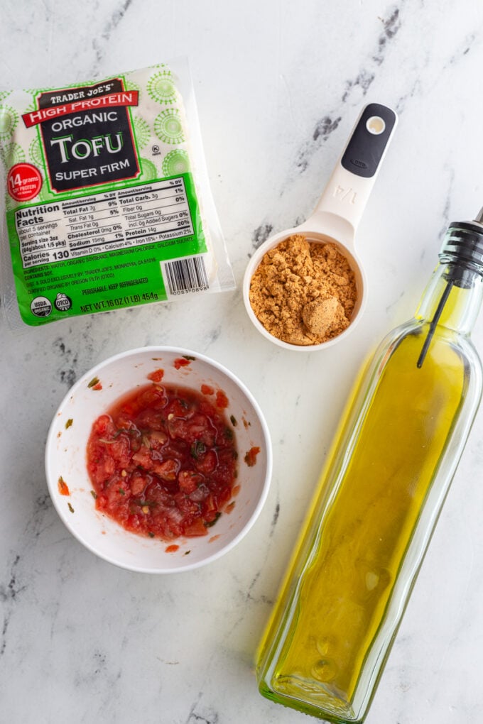 ingredients needed for shredded tofu taco meat including tofu, taco seasoning, salsa, and olive oil