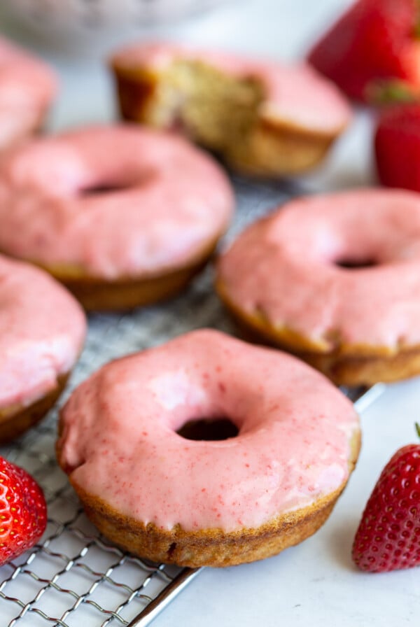 baked donuts topped with a pink strawberry glaze