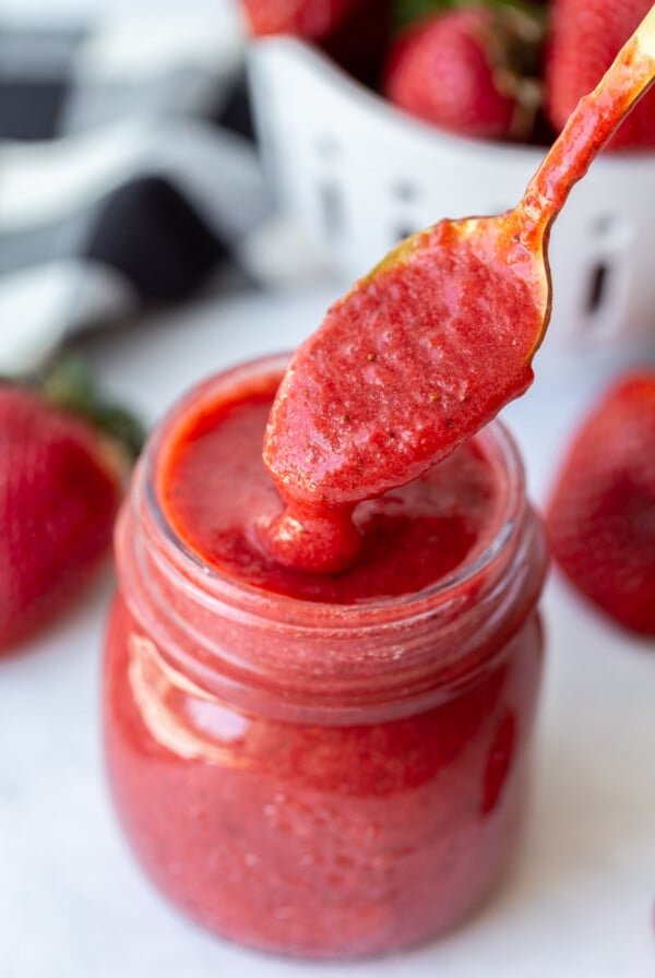 strawberry puree being spooned out of a jar